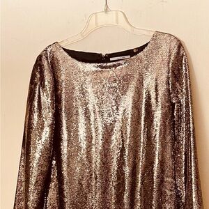 Glittering fabric drapes into a sophisticated Gold sheath dress.